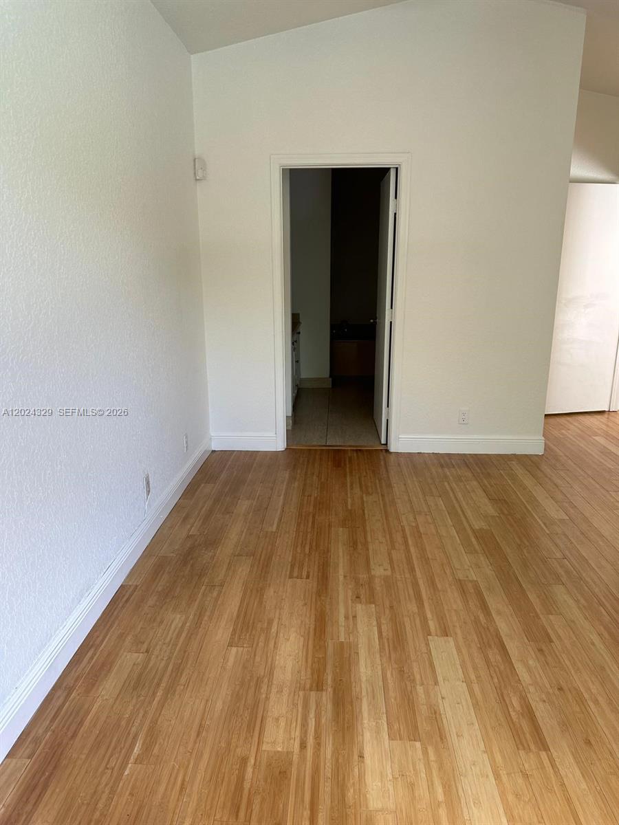 An interior view shows a room with light-colored walls, wood-look flooring, and an open doorway — 11090 Baybreeze Way # 11090, Boca Raton FL 33428, BOCA RATON, FL