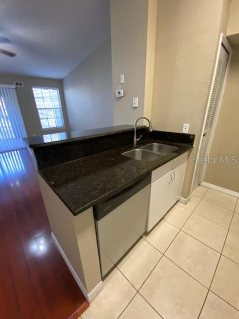 A kitchen features dark granite countertops, a stainless steel sink, and a dishwasher — 5028 PARK CENTRAL DRIVE UNIT 2128, ORLANDO, FL