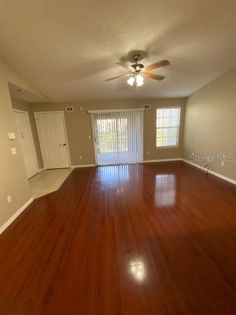 A living room with hardwood floors, a ceiling fan, and a sliding glass door — 5028 PARK CENTRAL DRIVE UNIT 2128, ORLANDO, FL