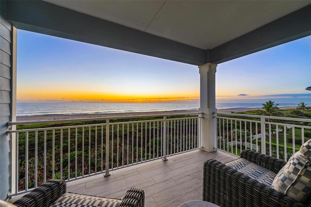 A covered balcony with tile flooring overlooks the ocean at sunset — 4860 WATERSONG WAY, FORT PIERCE, FL