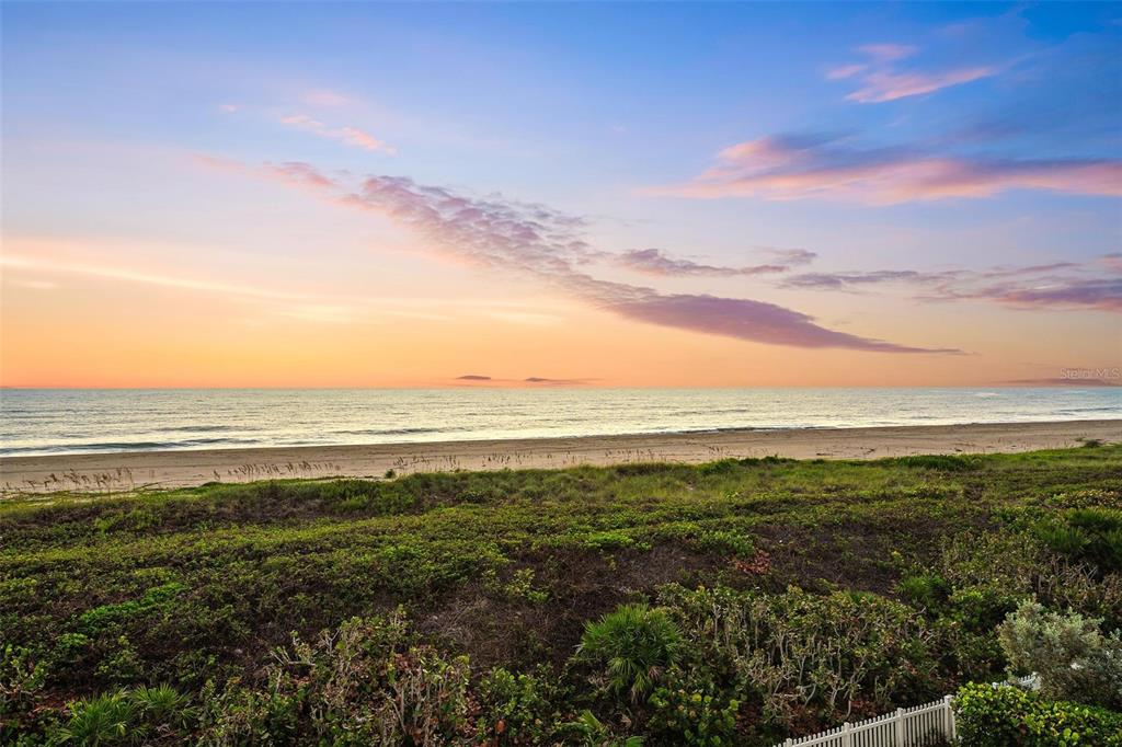 A view of a sandy beach and ocean at sunset beyond a grassy dune — 4860 WATERSONG WAY, FORT PIERCE, FL