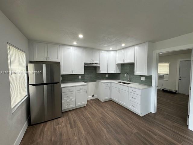 A kitchen with white cabinets, stainless steel refrigerator, and wood-look flooring — 101 W 11th St # 2, Riviera Beach FL 33404, RIVIERA BEACH, FL
