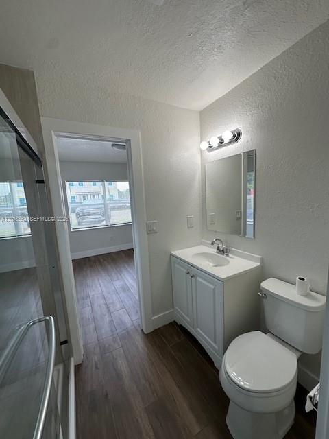 A bathroom with a white vanity, a toilet, a shower, and a doorway to another room — 101 W 11th St # 2, Riviera Beach FL 33404, RIVIERA BEACH, FL