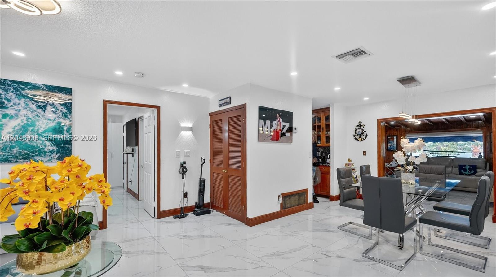 A dining area with marble-look tile floors, a glass table, and a wooden closet door — 15022 SW 67th Ln, Miami FL 33193, MIAMI, FL
