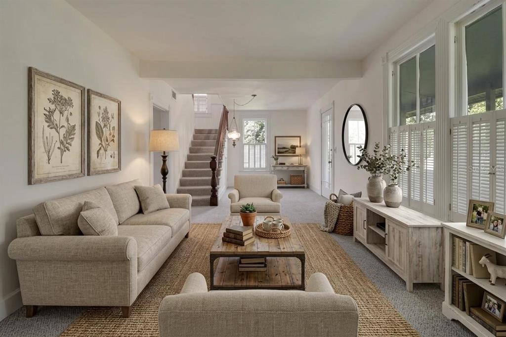A living room features a beige sofa, two armchairs, a wooden coffee table, and stairs — 900 E KICKLIGHTER (5 +- ACRES) ROAD, LAKE HELEN, FL