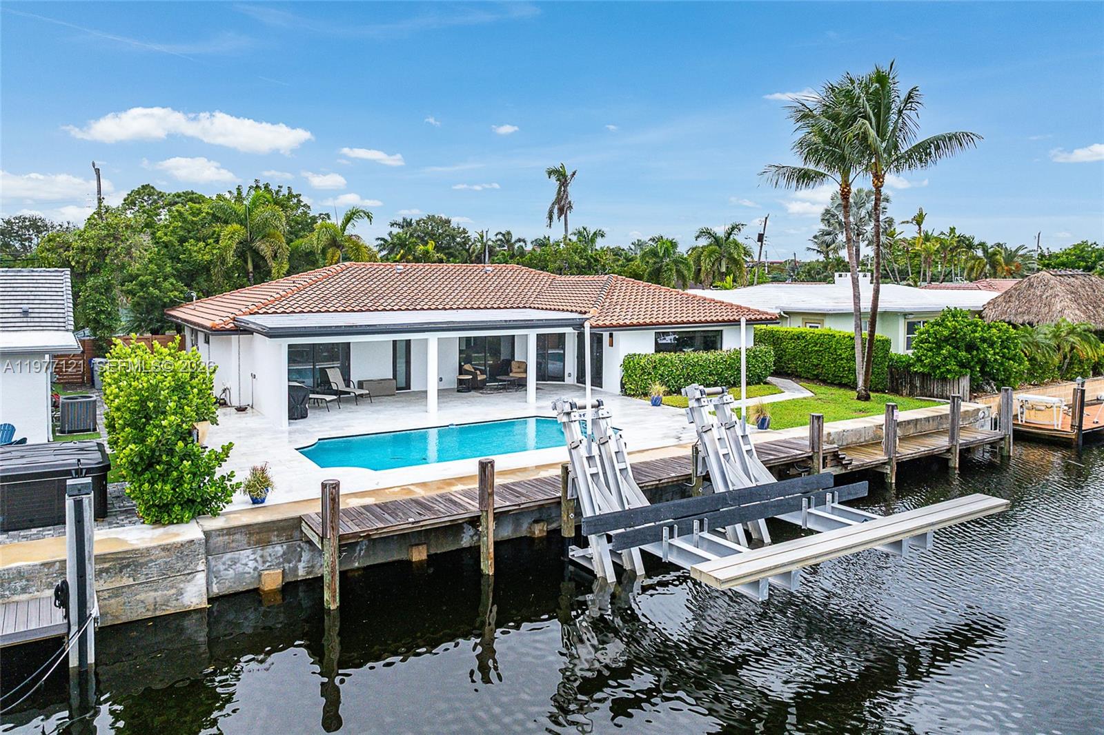 An aerial view shows a waterfront house with a swimming pool and a boat lift — 1250 NE 27th Terrace, Pompano Beach FL 33062, POMPANO BEACH, FL