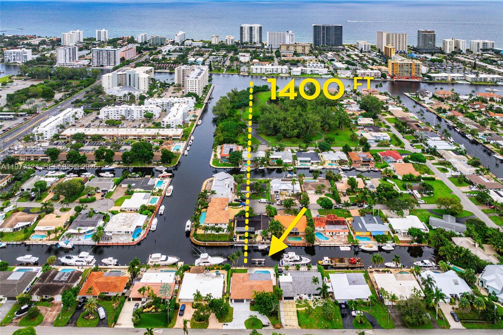 An aerial view shows a waterfront residential neighborhood with a canal and nearby park — 1250 NE 27th Terrace, Pompano Beach FL 33062, POMPANO BEACH, FL