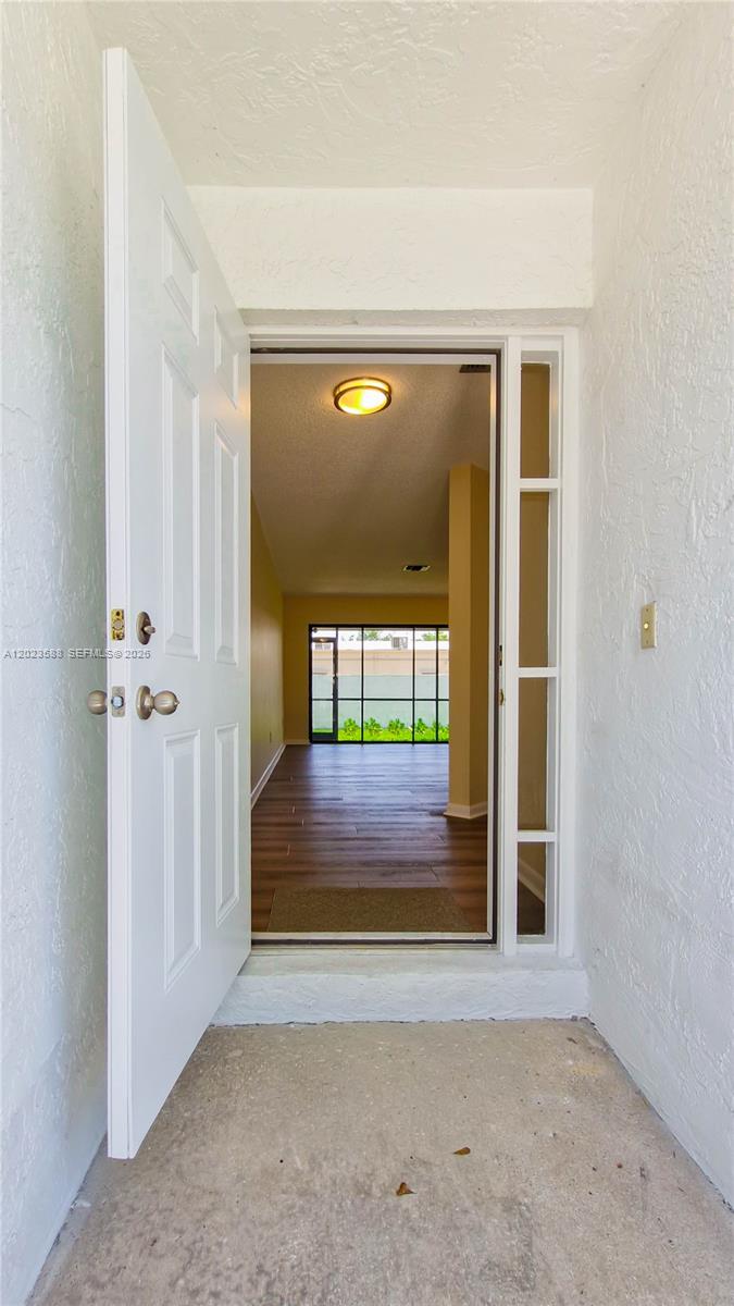 An exterior view of a white house with a red tile roof and a small garden — 275 NW 36th Ave # 275, Deerfield Beach FL 33442, DEERFIELD BEACH, FL
