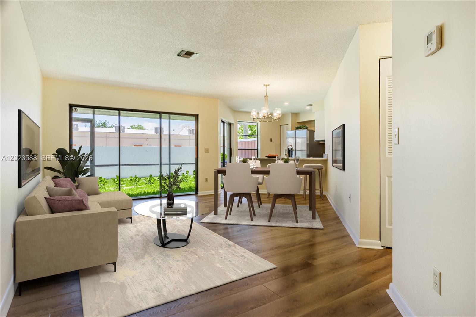 An open white front door reveals a living area with wood-look flooring and a lanai — 275 NW 36th Ave # 275, Deerfield Beach FL 33442, DEERFIELD BEACH, FL