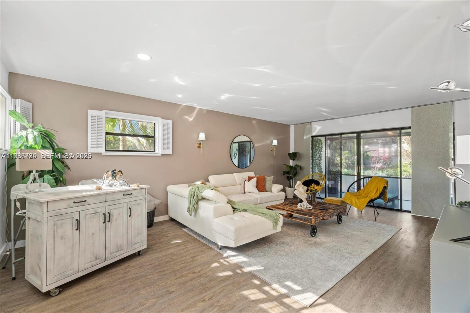 A living room features a white sectional sofa, a wooden coffee table, and sliding glass doors — 149 NW 70th St # 101C, Boca Raton FL 33487, BOCA RATON, FL