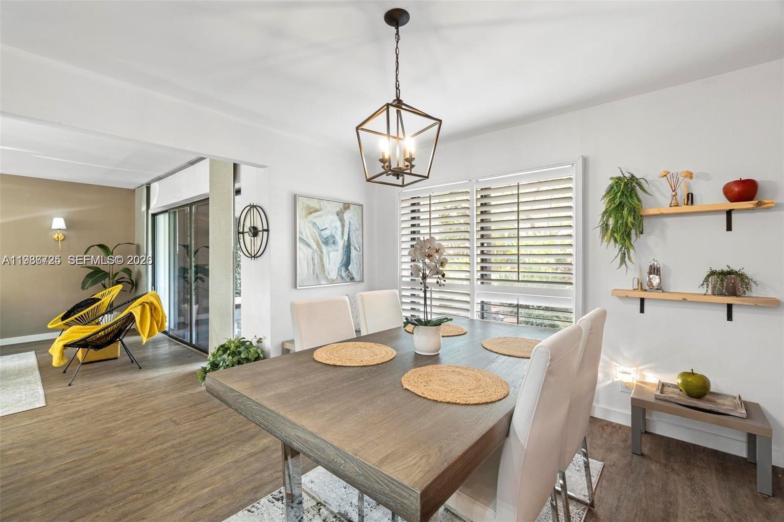 A dining room features a wooden table, white chairs, a geometric pendant light, and shelving — 149 NW 70th St # 101C, Boca Raton FL 33487, BOCA RATON, FL