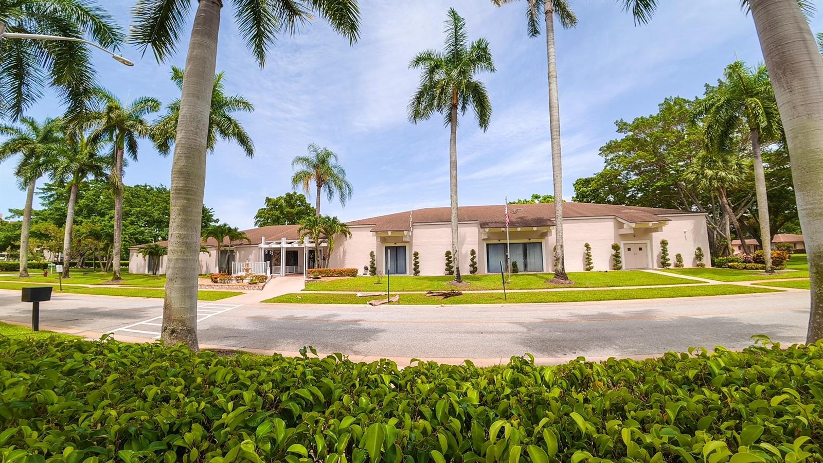A low-rise, light-colored building is surrounded by palm trees and a manicured lawn — 14790 Bonaire Boulevard # 210, Delray Beach FL 33446, DELRAY BEACH, FL
