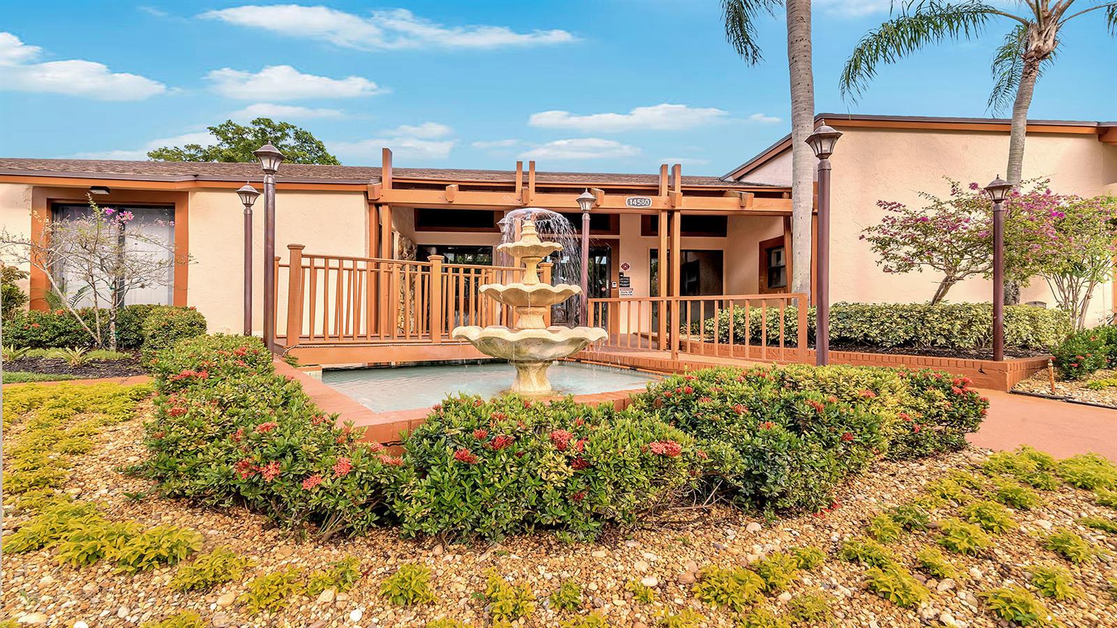 A multi-tiered fountain sits in front of a building entrance with a wooden bridge — 14790 Bonaire Boulevard # 210, Delray Beach FL 33446, DELRAY BEACH, FL