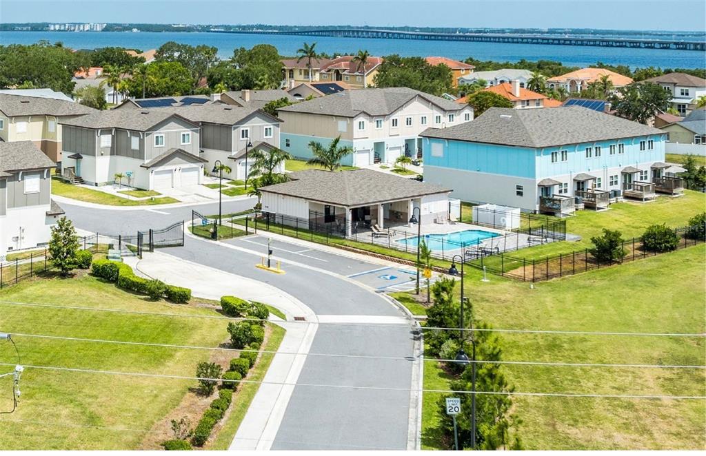 An aerial view shows a residential community with townhomes, a swimming pool, and a road — 3301 WHITNEY ROAD UNIT 2102, 2104, 2106, Et al., CLEARWATER, FL