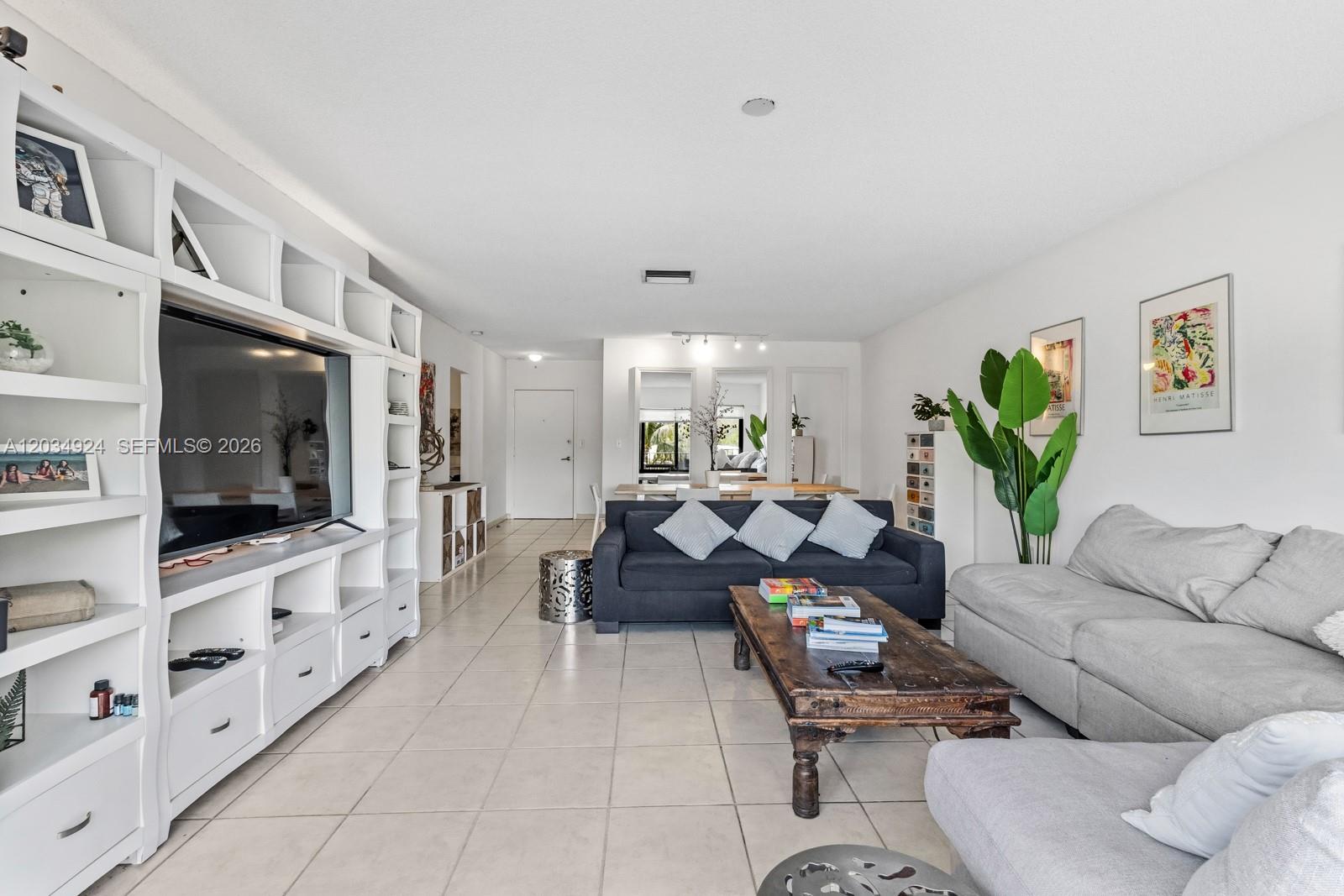 A living room features a large white entertainment unit, a dark sofa, and a light-colored sectional — 575 Crandon Blvd # 413, Key Biscayne FL 33149, KEY BISCAYNE, FL