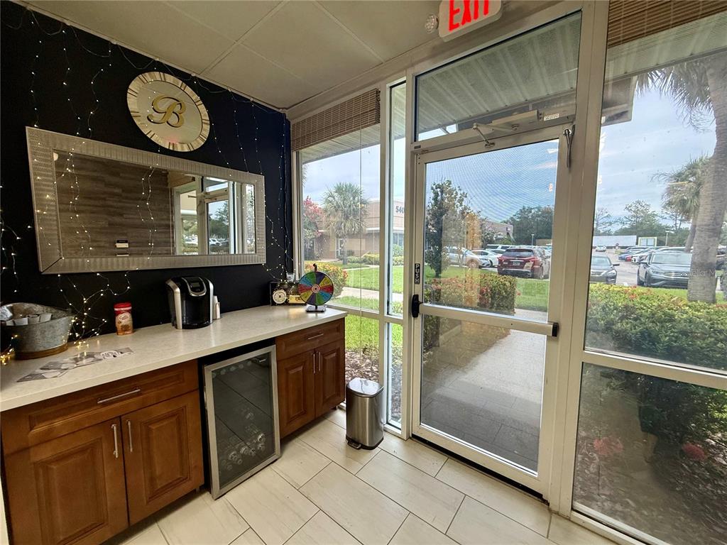 A small office break area features wood cabinets, a beverage cooler, and a glass door — 5404 HOOVER BOULEVARD UNIT 24, TAMPA, FL