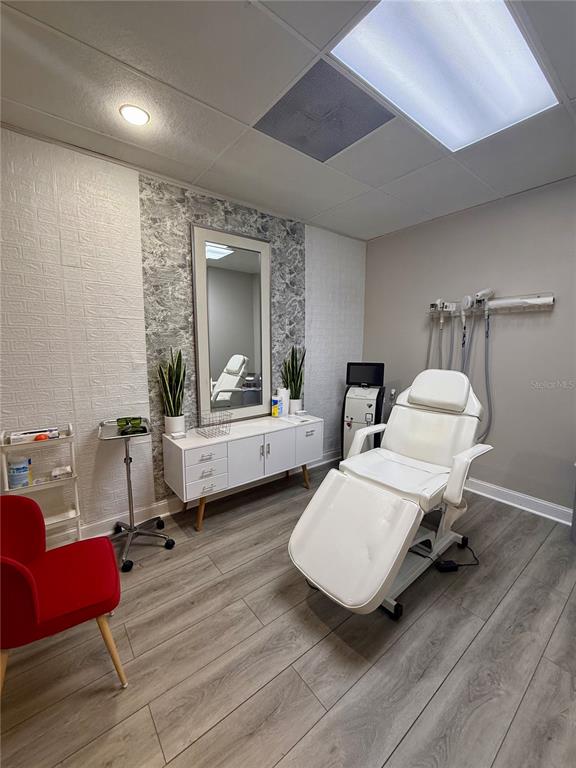 A treatment room features a white medical chair, a storage cabinet, and a wall mirror — 5404 HOOVER BOULEVARD UNIT 24, TAMPA, FL