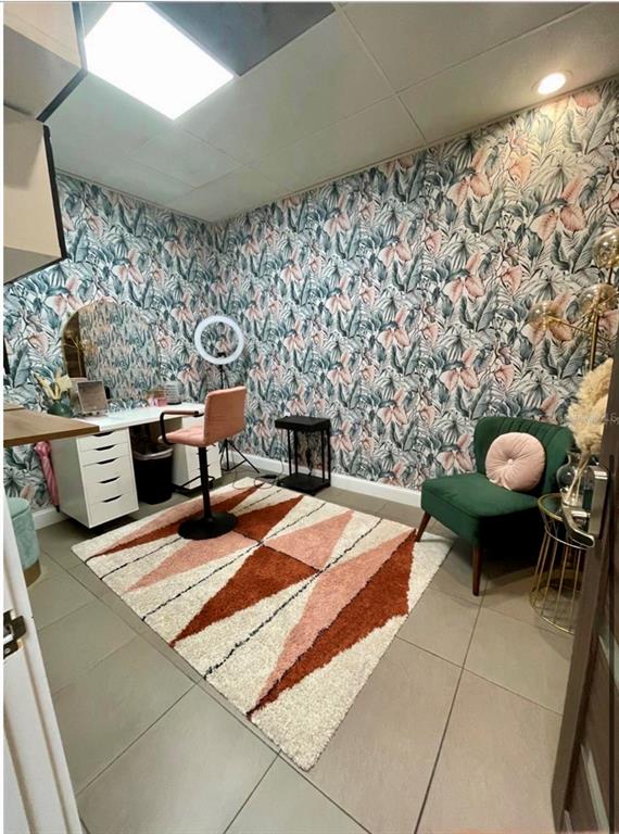 A small room features patterned botanical wallpaper, a desk with a vanity mirror, and a rug — 5404 HOOVER BOULEVARD UNIT 24, TAMPA, FL