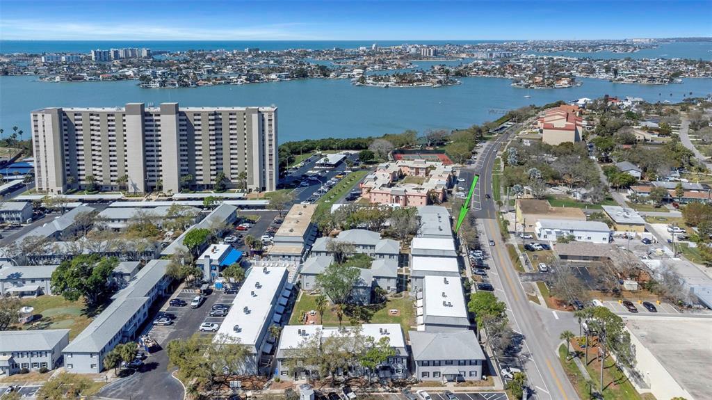 An aerial view shows a multi-building apartment complex near a large body of water — 6976 SUNSET DRIVE S UNIT 6976, ST PETERSBURG, FL