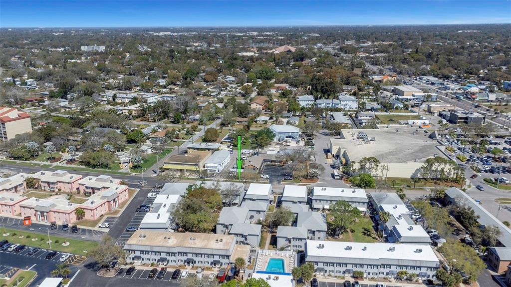 An aerial view shows a residential complex with a pool and a green arrow marker — 6976 SUNSET DRIVE S UNIT 6976, ST PETERSBURG, FL