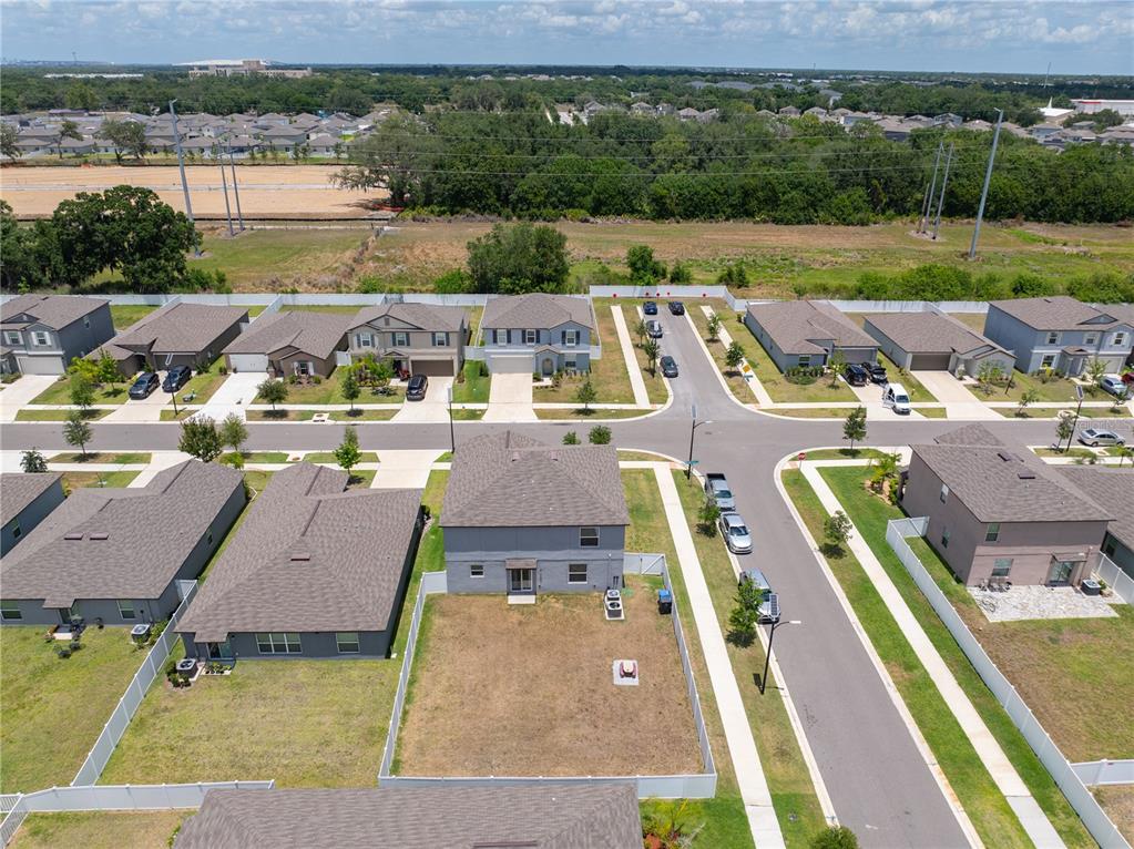 An aerial view shows a suburban neighborhood with single-family homes and a fenced backyard — 10291 SHADY PRESERVE DRIVE, RIVERVIEW, FL
