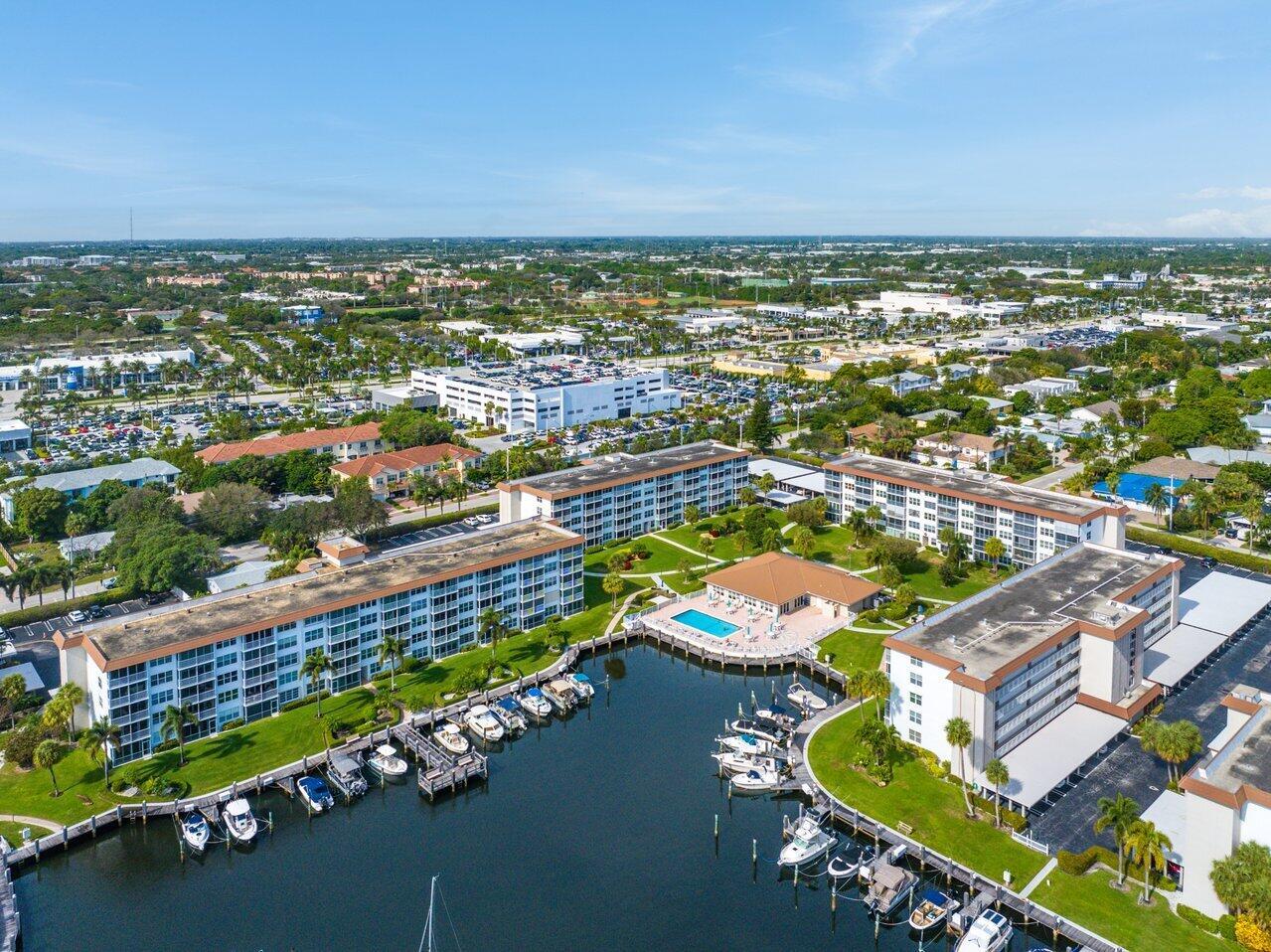 An aerial view of a waterfront apartment complex with a pool and boat docks — 2525 Florida Boulevard # 130, Delray Beach FL 33483, DELRAY BEACH, FL