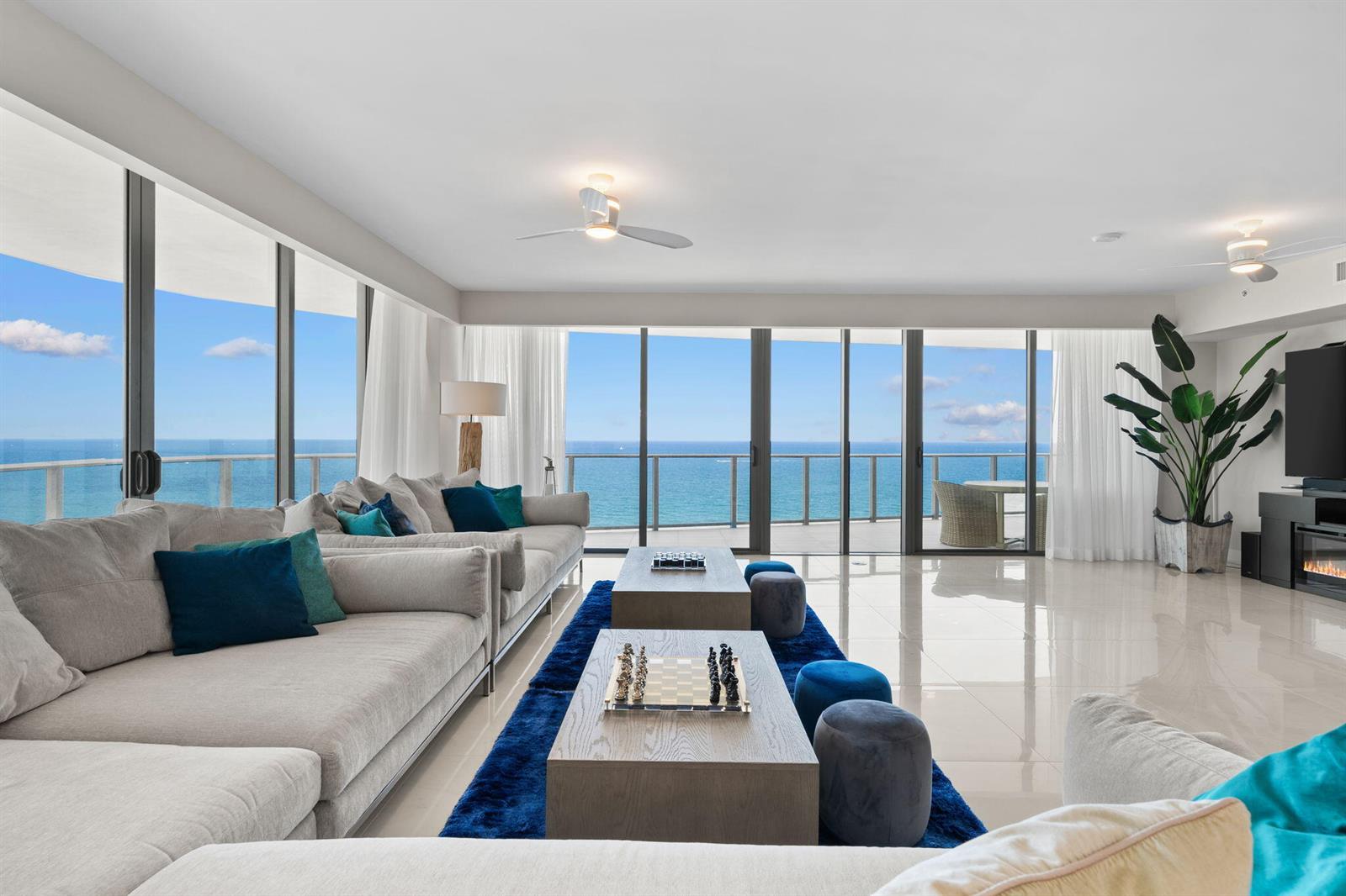 A modern living room features a large sectional sofa, two coffee tables, and floor-to-ceiling ocean views — 730 N Ocean Boulevard # 1703, Pompano Beach FL 33062, POMPANO BEACH, FL