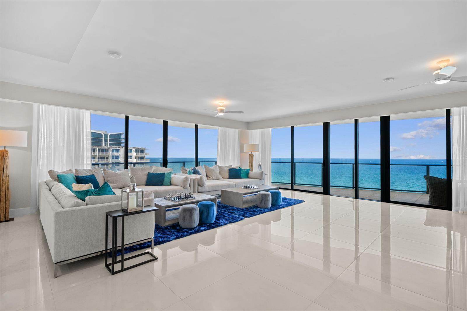A spacious living room with white tile floors, a blue rug, and floor-to-ceiling ocean views — 730 N Ocean Boulevard # 1703, Pompano Beach FL 33062, POMPANO BEACH, FL
