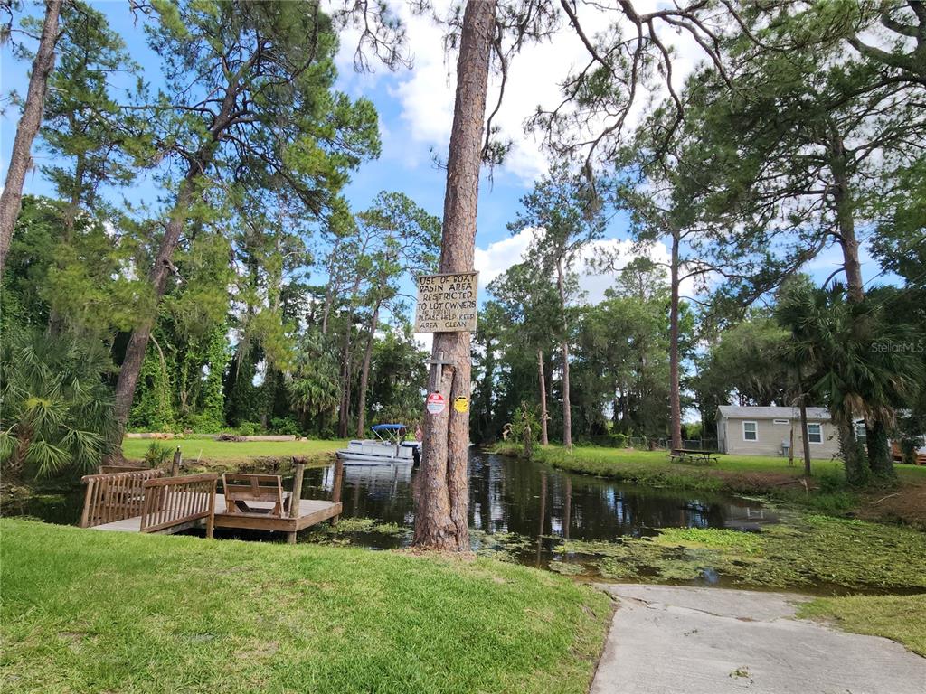 A boat basin with a wooden dock, a boat, and a restricted access sign — 22835 SW 117TH PLACE ROAD, DUNNELLON, FL