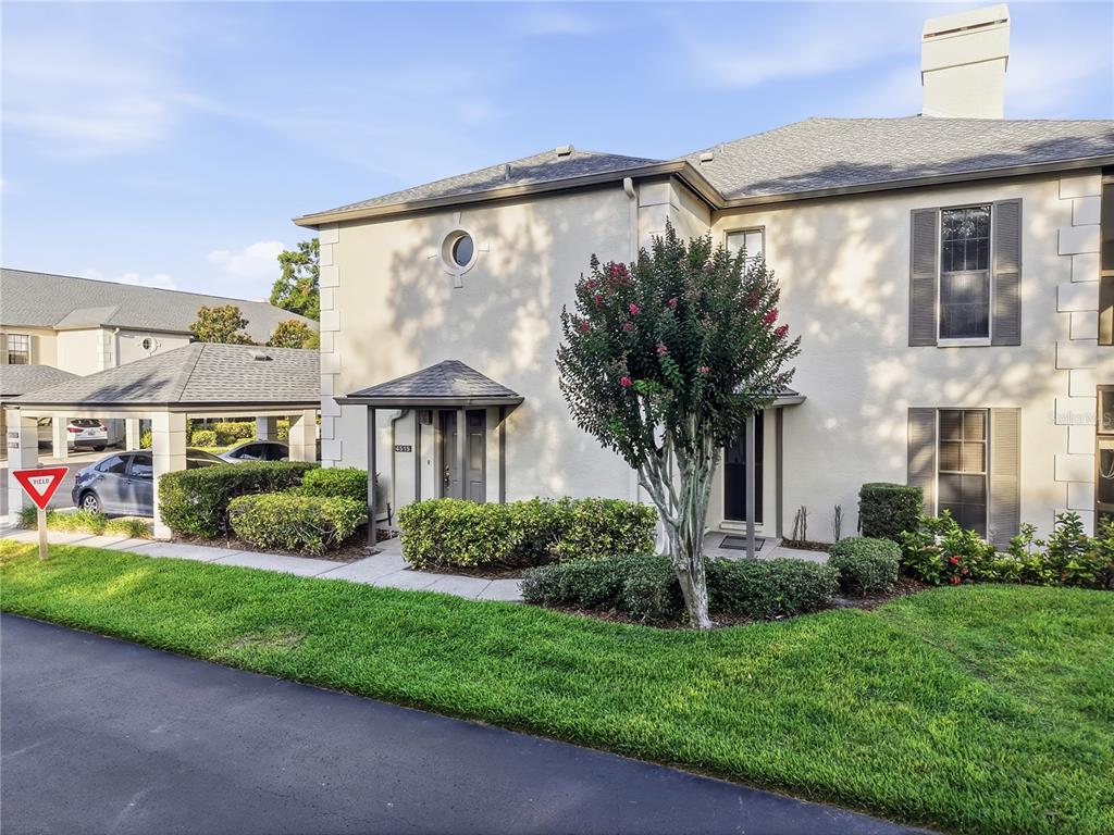 A two-story stucco townhouse features a covered entryway, a circular window, and a carport — 4515 SOUTHAMPTON COURT UNIT 4515, TAMPA, FL