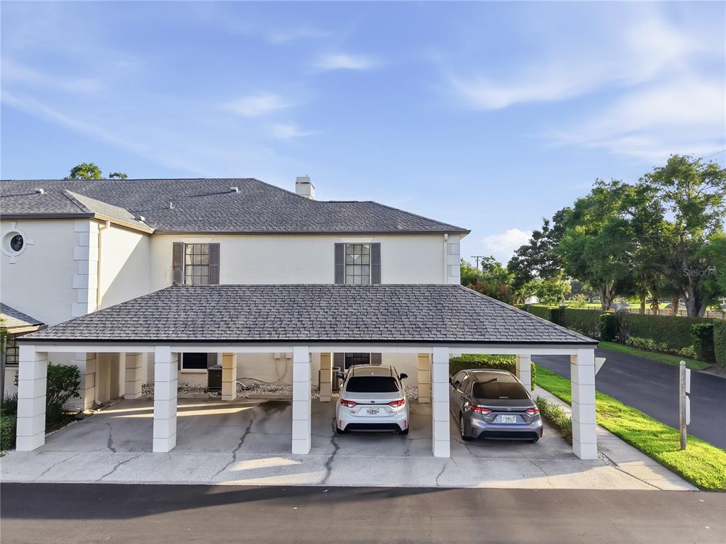 A two-story building features a covered carport with two parked cars on a concrete driveway — 4515 SOUTHAMPTON COURT UNIT 4515, TAMPA, FL