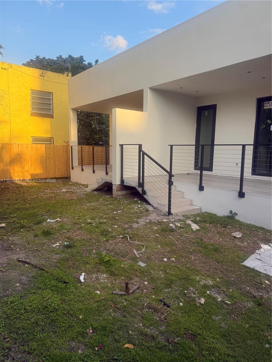 The exterior of a modern house features a raised deck with metal railings and stairs — 1730 NW 16th St, Miami FL 33125, MIAMI, FL