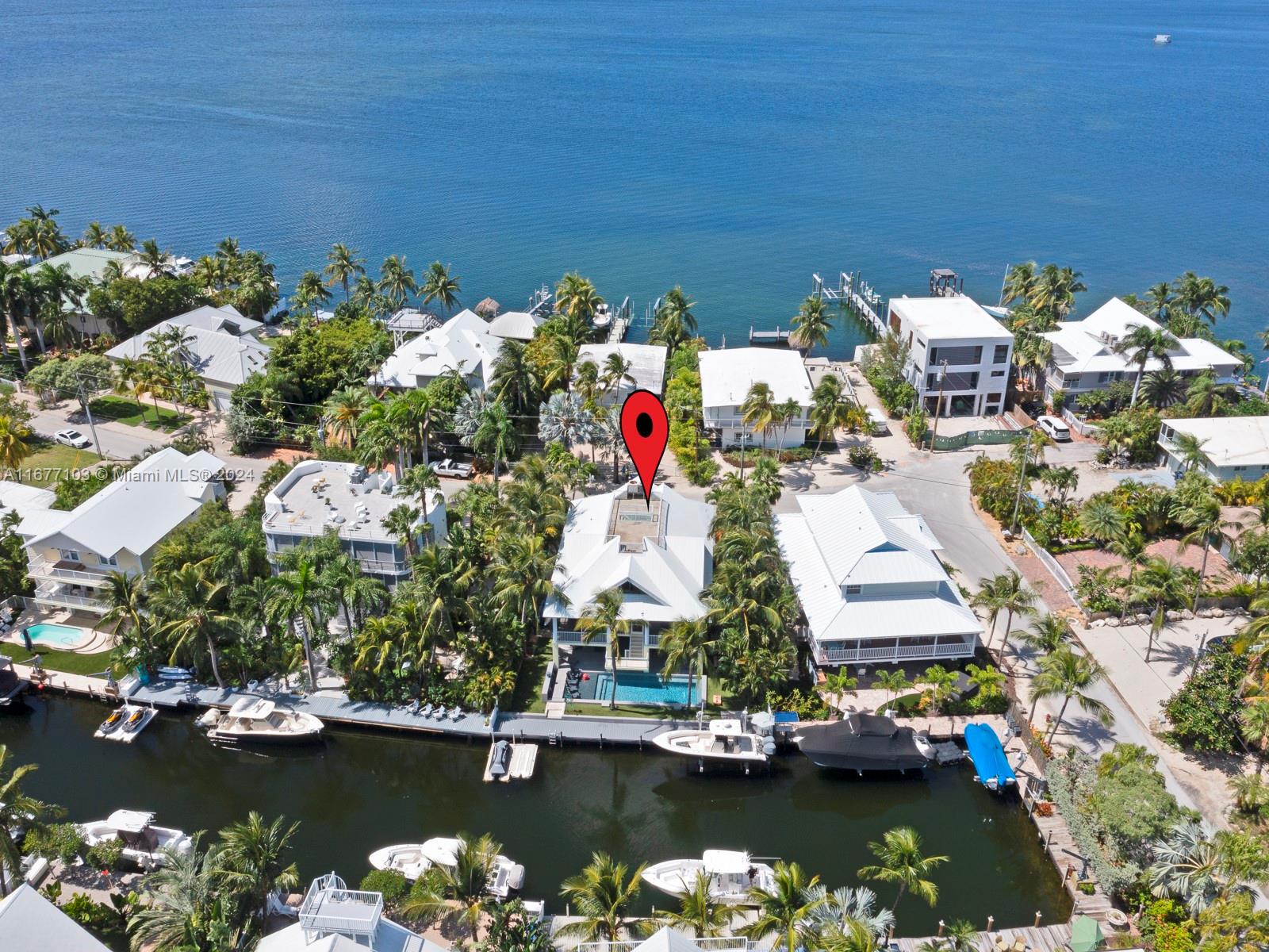 An aerial view shows a waterfront house with a pool and boat dock — 3 North Dr, Key Largo FL 33037, KEY LARGO, FL