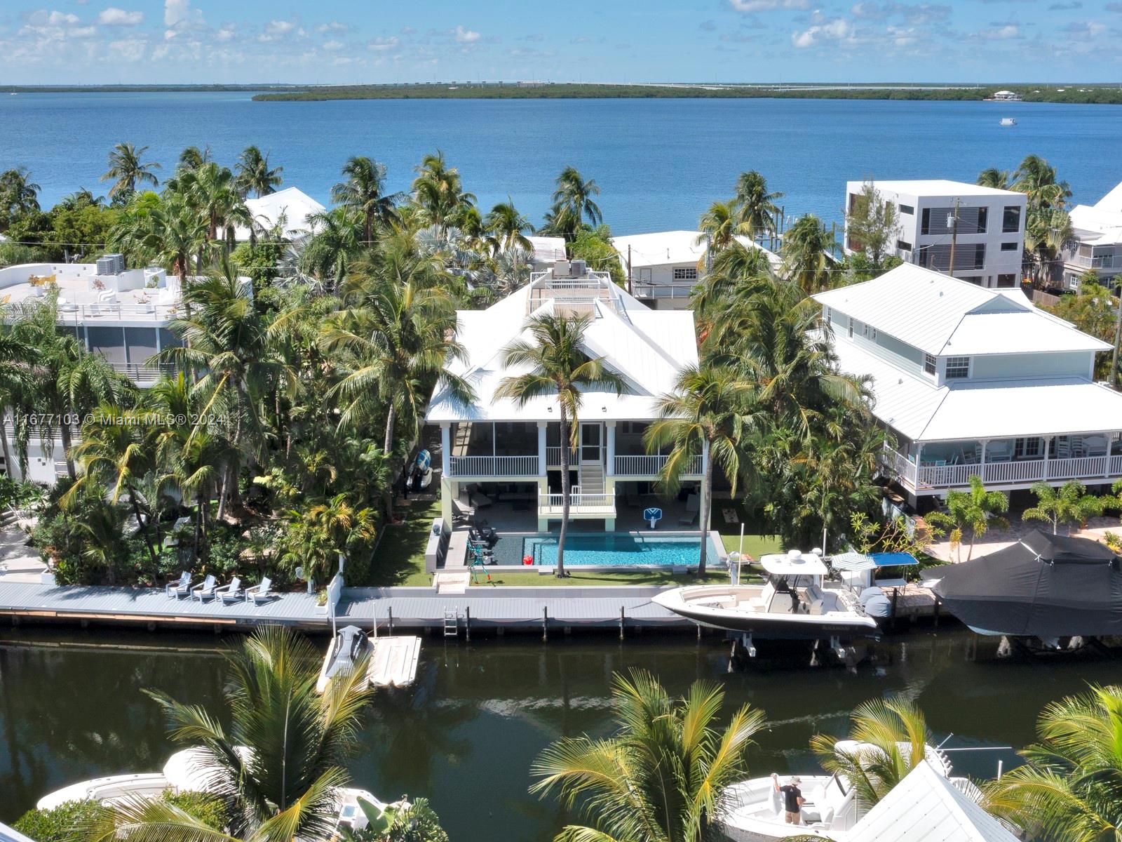 An aerial view shows a waterfront house with a pool, dock, and boats — 3 North Dr, Key Largo FL 33037, KEY LARGO, FL