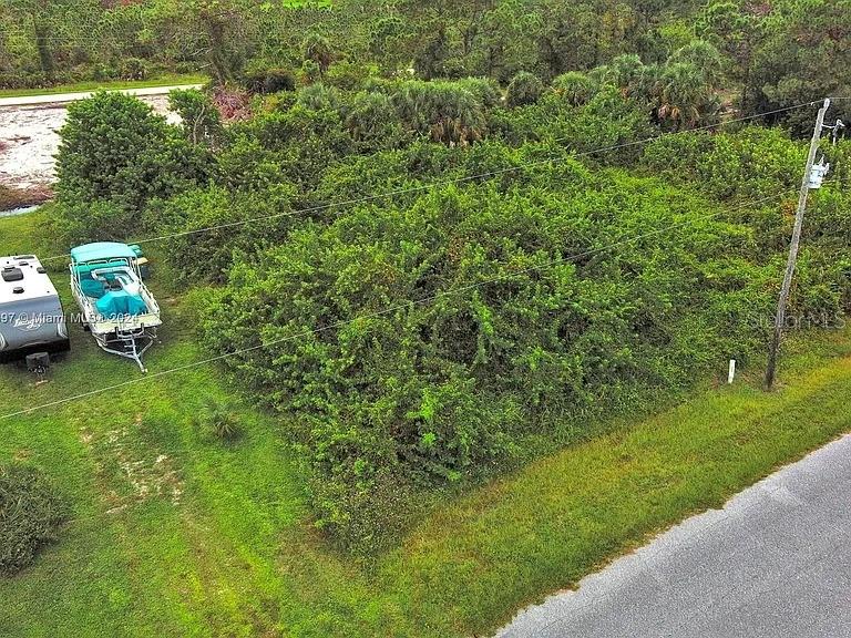 An aerial view shows a vacant, overgrown lot with a boat and camper parked nearby — 4137 CHIPPEWA STREET, PORT CHARLOTTE, FL
