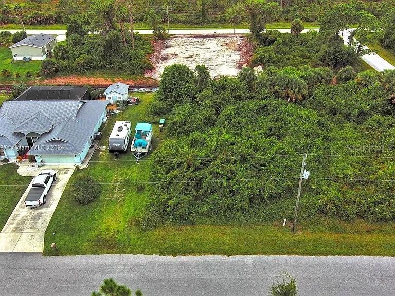 An aerial view shows a house, a driveway, a boat, and a large wooded lot — 4137 CHIPPEWA STREET, PORT CHARLOTTE, FL
