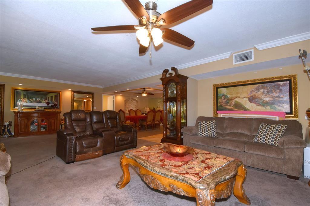 A living room features a brown leather sofa, a fabric couch, and a grandfather clock — 111 N Pompano Beach Boulevard # 304, Pompano Beach FL 33062, POMPANO BEACH, FL