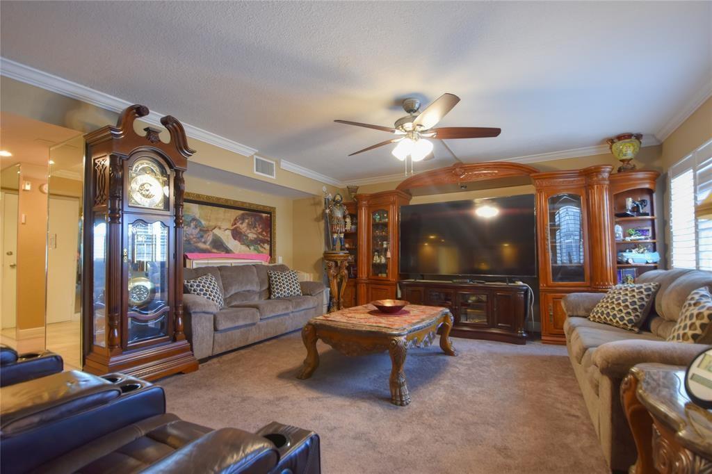 A living room features a grandfather clock, a large television, and two brown sofas — 111 N Pompano Beach Boulevard # 304, Pompano Beach FL 33062, POMPANO BEACH, FL