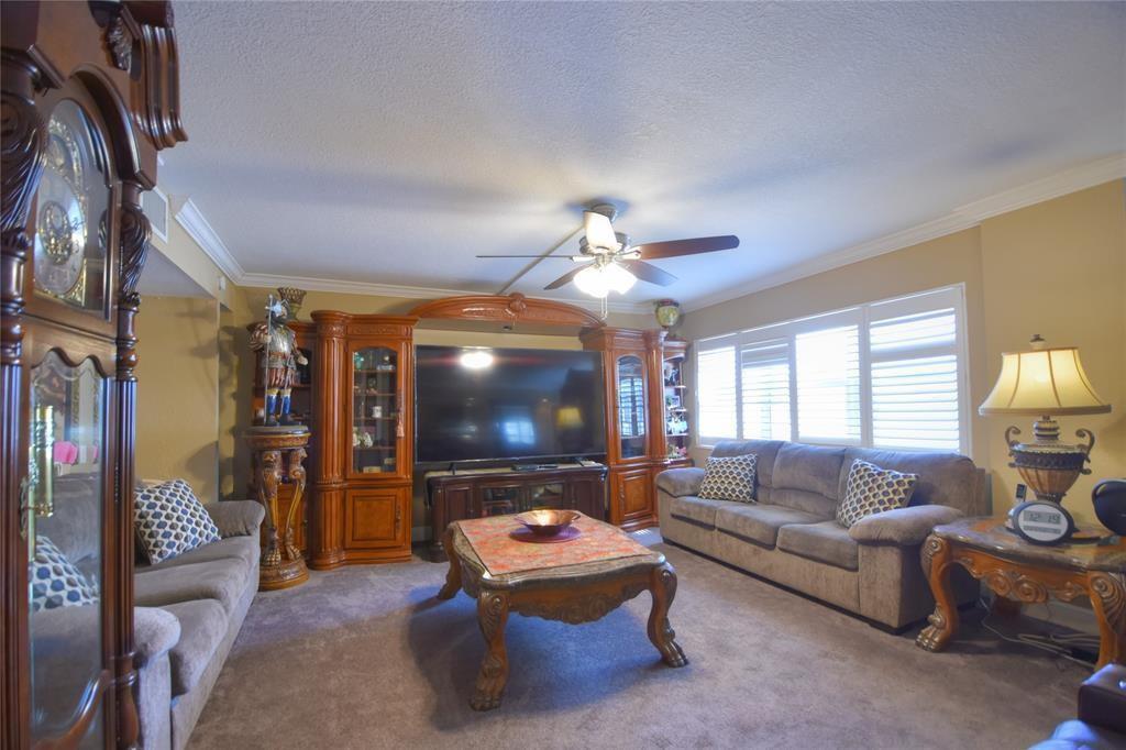 A living room features a large entertainment center, two sofas, a coffee table, and carpeted floors — 111 N Pompano Beach Boulevard # 304, Pompano Beach FL 33062, POMPANO BEACH, FL