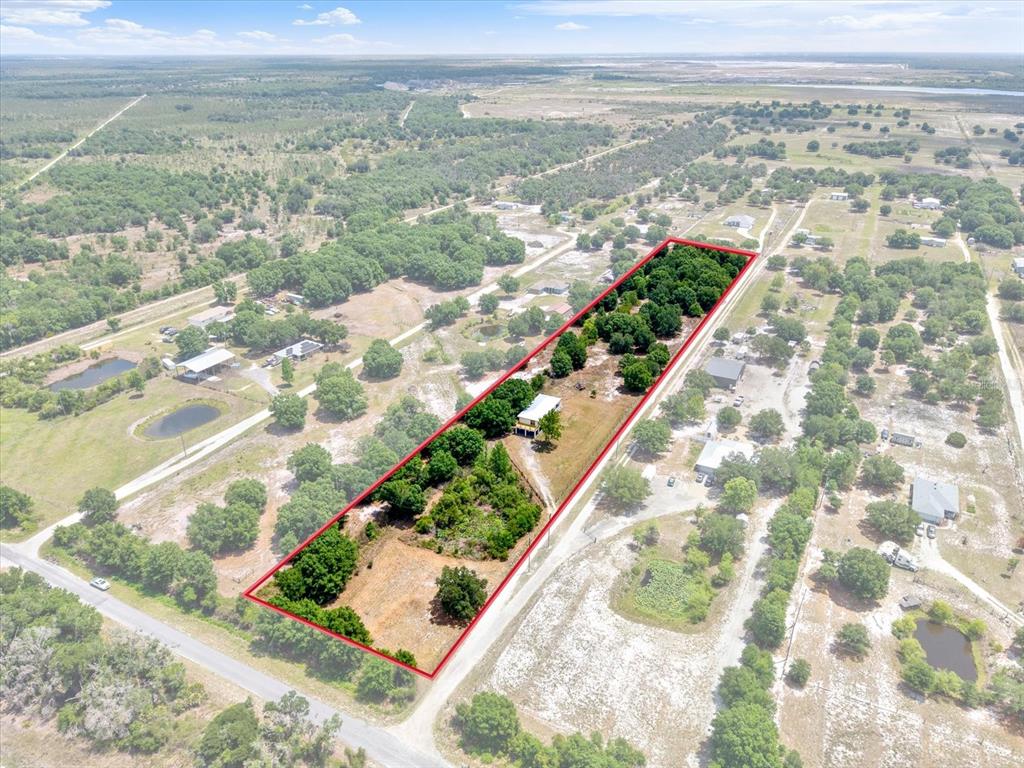 An aerial view shows a rectangular property outlined in red containing a house and trees — 464 LOGUE ROAD, MYAKKA CITY, FL