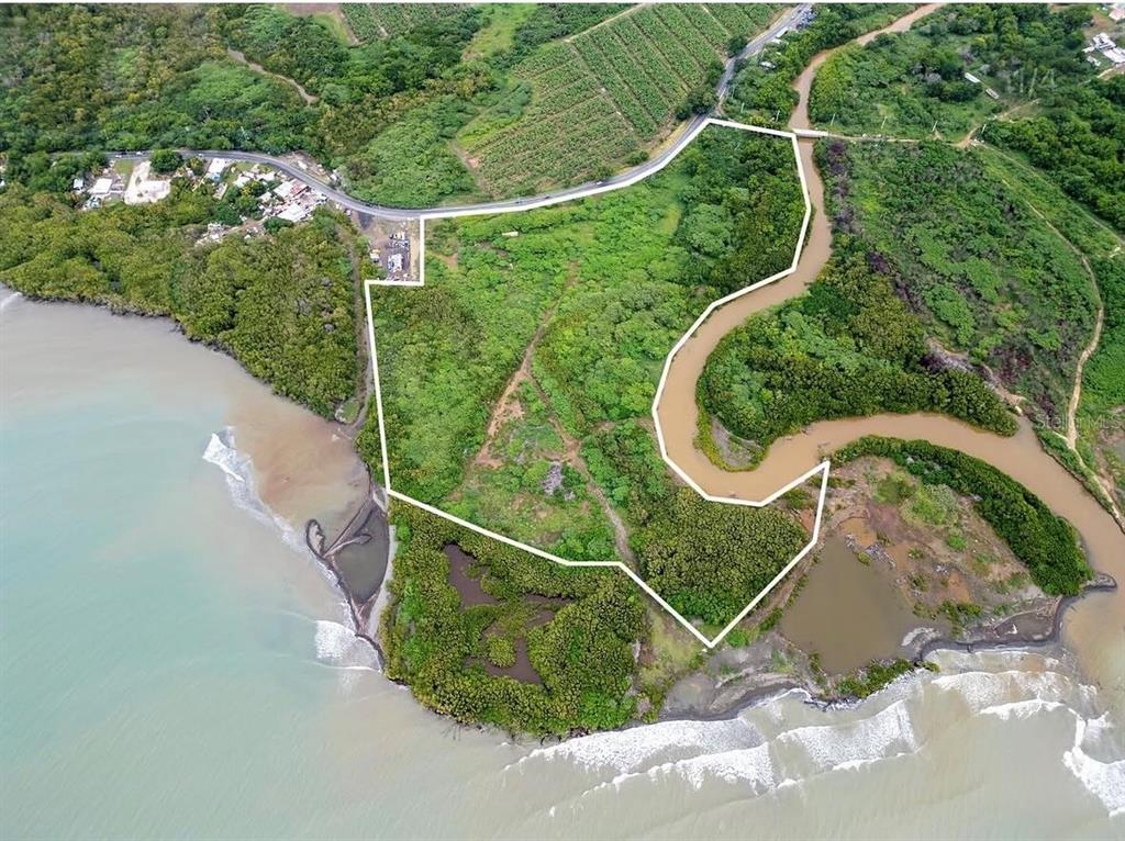 An aerial view shows a coastal plot of land outlined in white near a river — 92 CARRETERA 1, SALINAS, PR