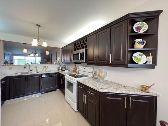 A kitchen features dark wood cabinets, granite countertops, a white stove, and a pass-through window — 2603 NW 103rd Avenue, Sunrise FL 33322, SUNRISE, FL