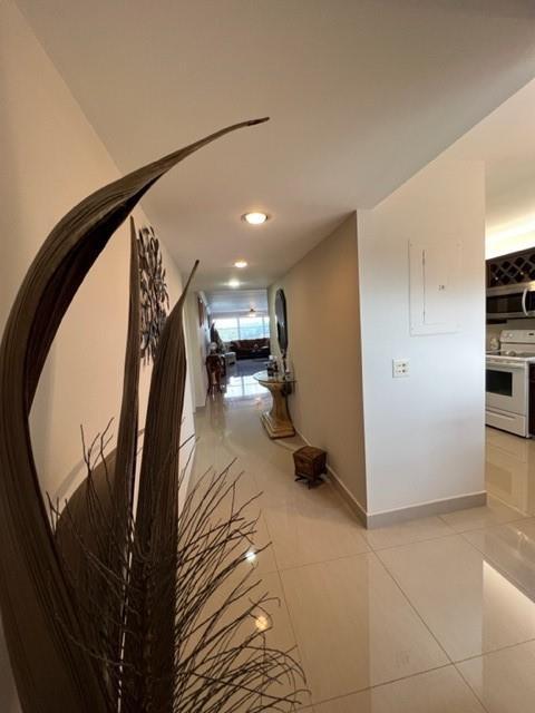A hallway with light tile flooring leads toward a living area with a distant window — 2603 NW 103rd Avenue, Sunrise FL 33322, SUNRISE, FL