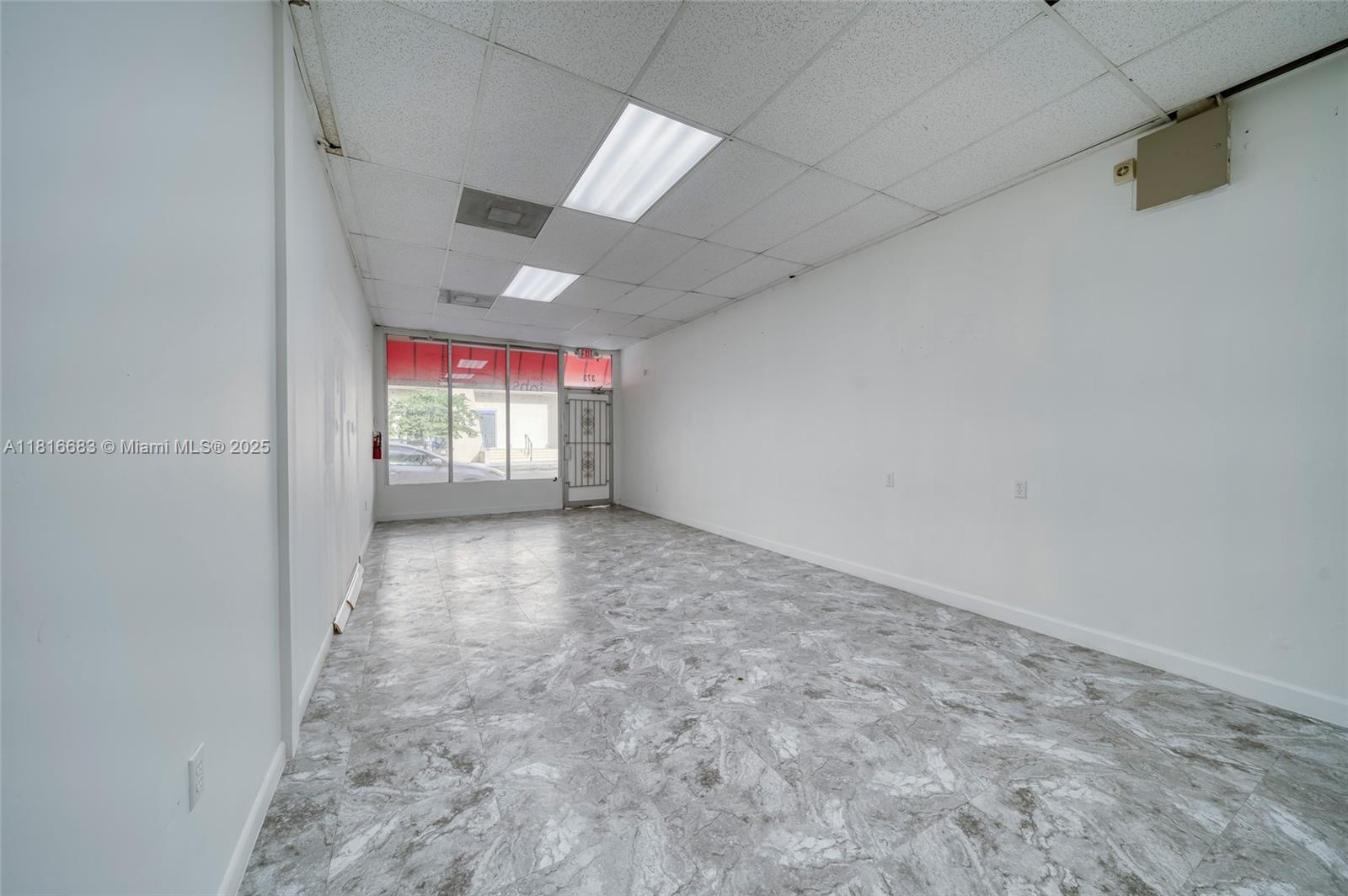 A vacant commercial space features white walls, a drop ceiling, and gray marble-patterned tile flooring — 363 E 1st Ave, Miami FL 33010, MIAMI, FL