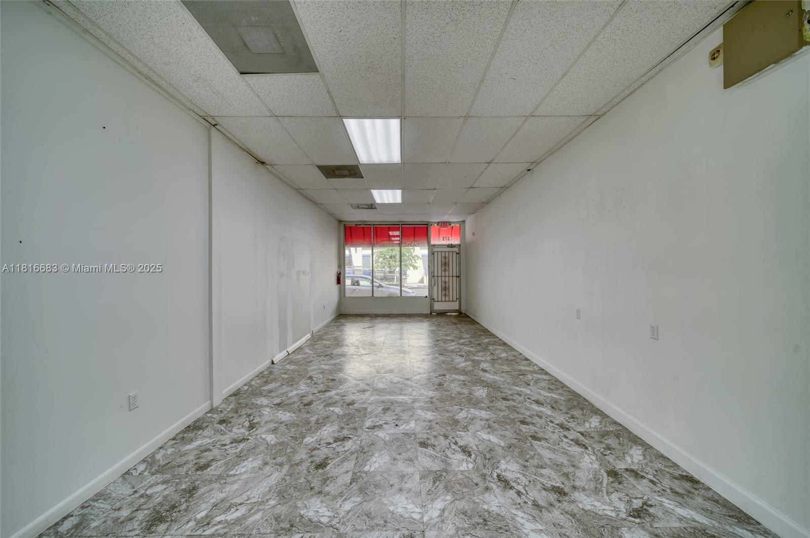 An empty commercial space features white walls, a drop ceiling, and gray marble-patterned flooring — 363 E 1st Ave, Miami FL 33010, MIAMI, FL