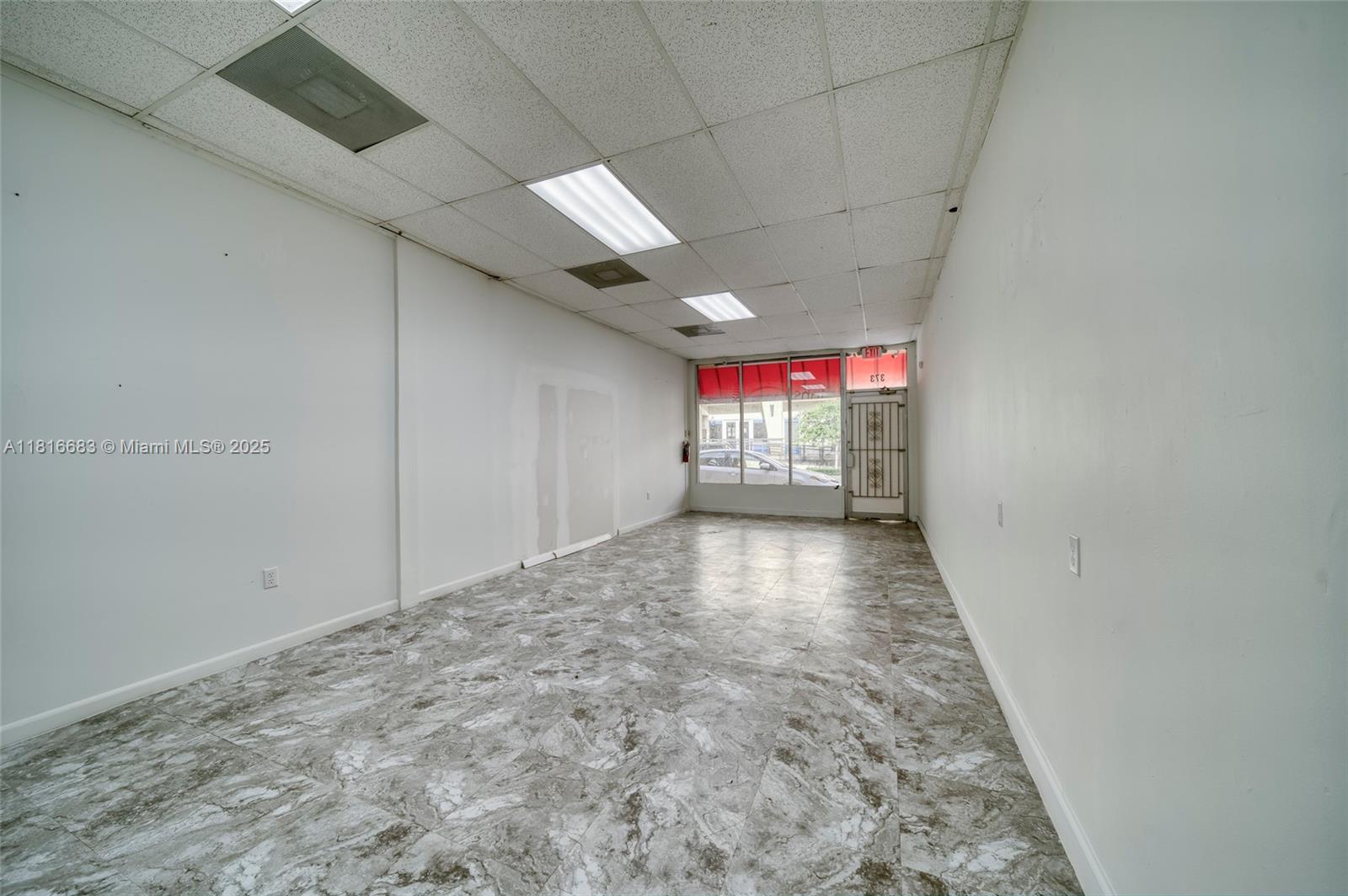 An empty commercial space features white walls, a drop ceiling, and gray marble-patterned tile flooring — 363 E 1st Ave, Miami FL 33010, MIAMI, FL