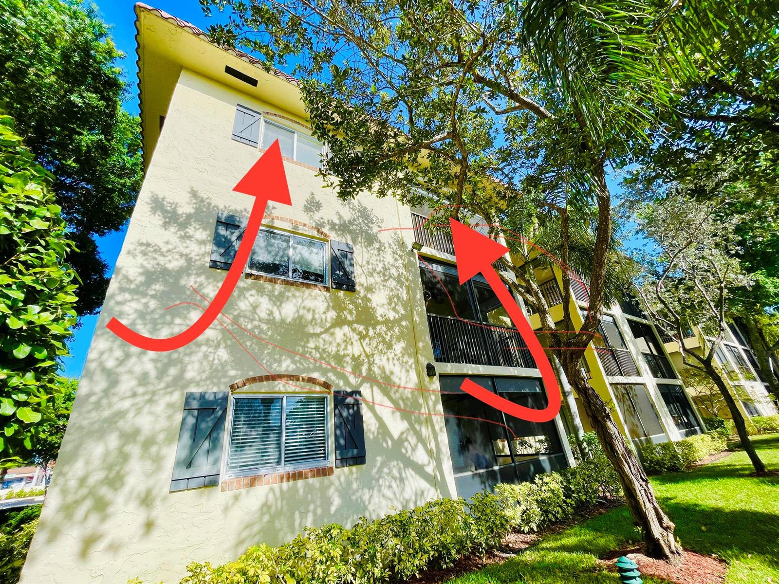 Exterior view of a three-story apartment building with stucco walls, shutters, and screened balconies — 257 S Cypress Road # 442, Pompano Beach FL 33060, POMPANO BEACH, FL