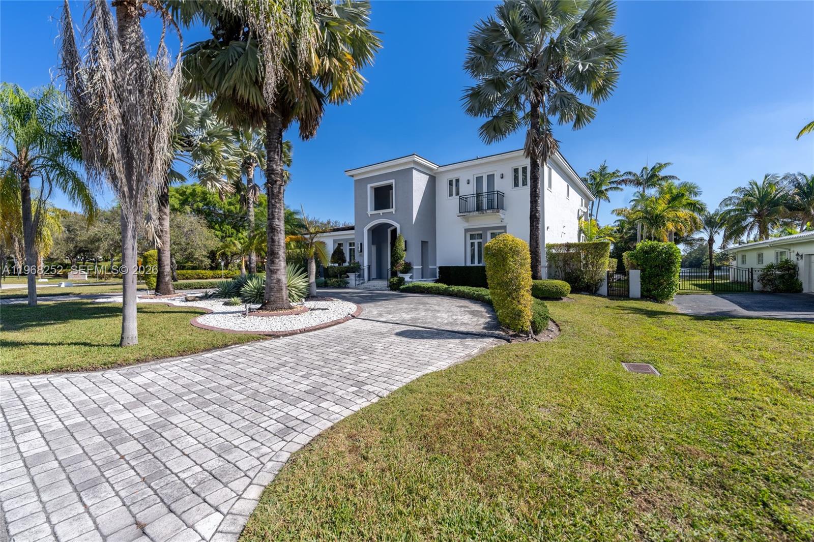 A two-story white and gray house features a paved driveway and several tall palm trees — 12755 SW 57th Ave, Coral Gables FL 33156, CORAL GABLES, FL