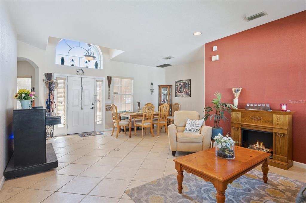A living room with tile floors, a fireplace, and a dining area near the entrance — 2930 WHITE CEDAR CIRCLE, KISSIMMEE, FL