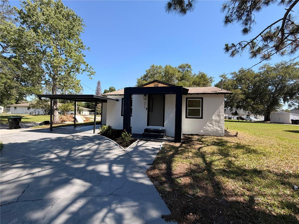 A white brick house with a black entryway frame and an attached carport — 211 BAYSHORE DRIVE, ORLANDO, FL